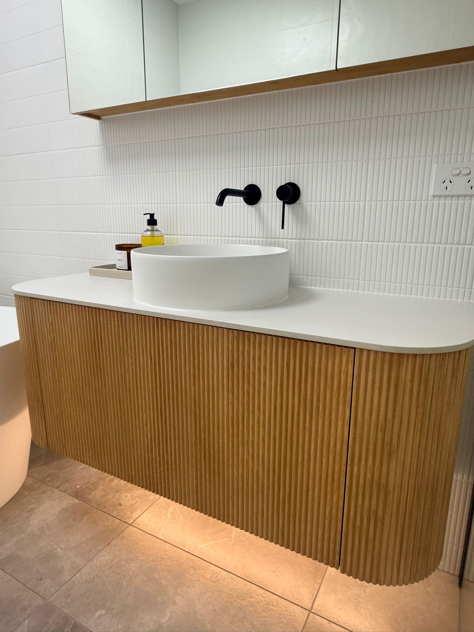 Finished wall hung timber vanity with round basin and wall tapware
