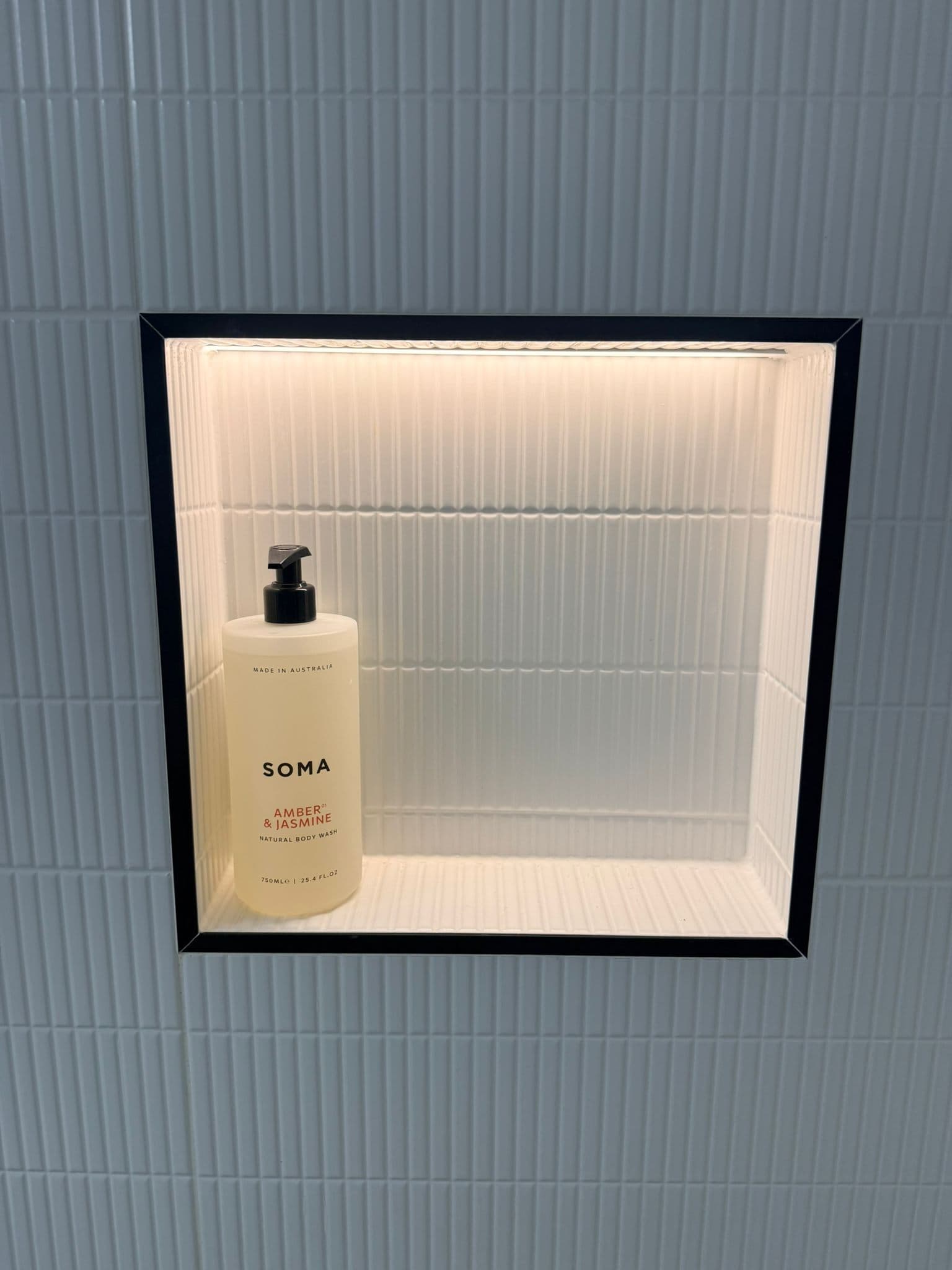 Recessed bathroom niche with LED lighting and black trim